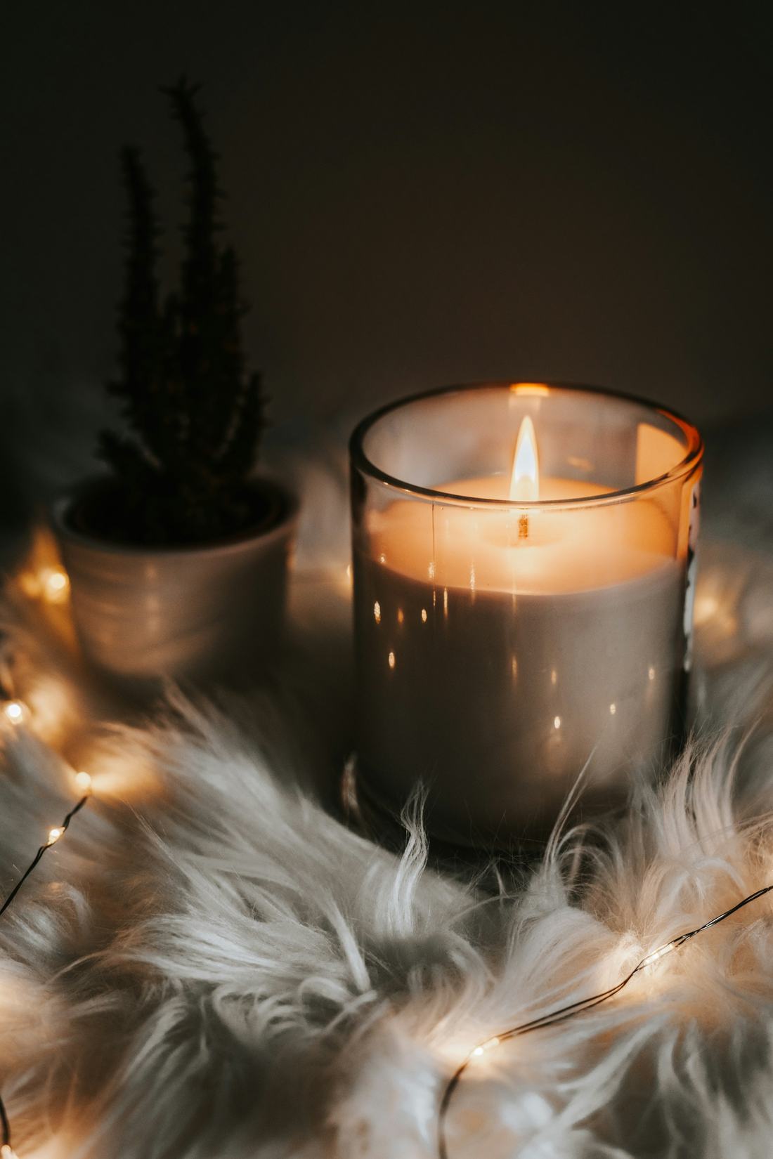 A single lit candle glowing in a dark room